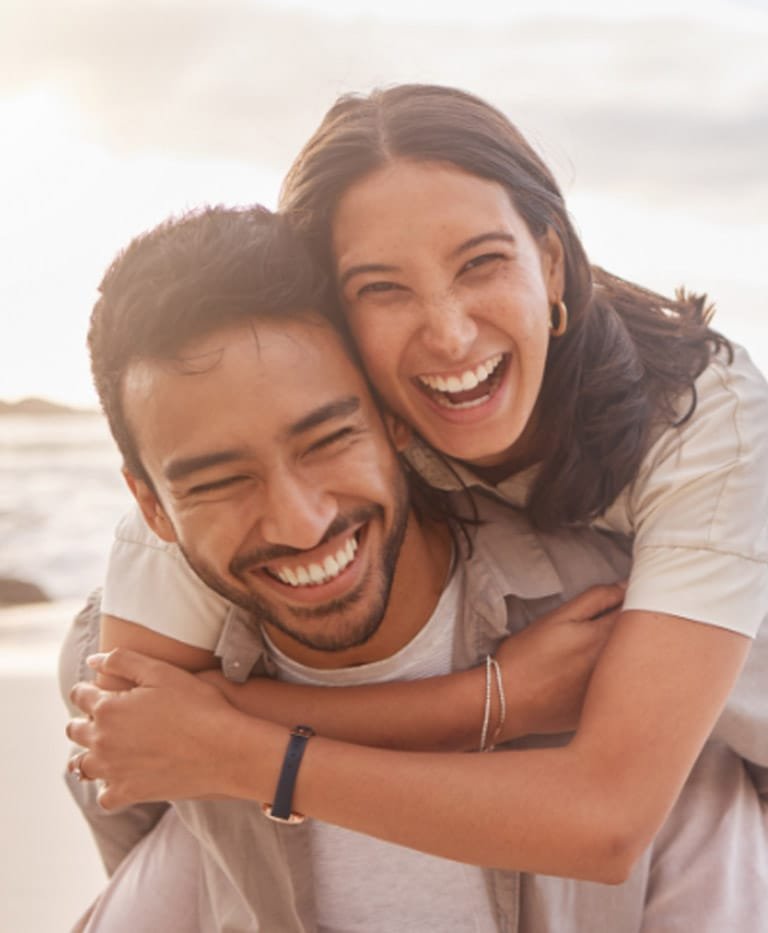 Couple laughing, female hugging the male from behind