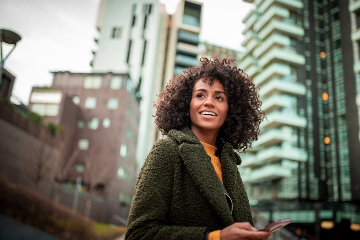 Woman outside with tall buildings in the background